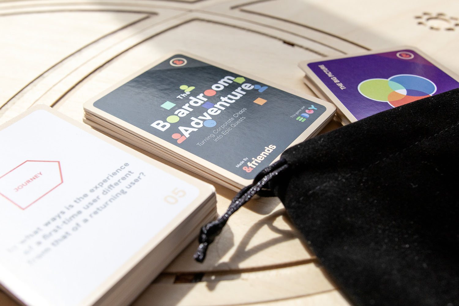 The game box and cards on a laser-cut wooden board