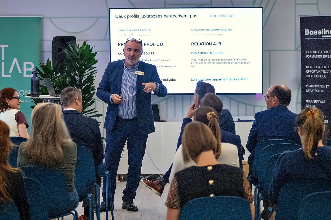 A speaker presenting a French-language session to a full room