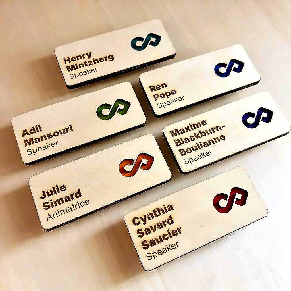 Six laser-engraved wooden name badges with the Intersection logo cut out in colour
